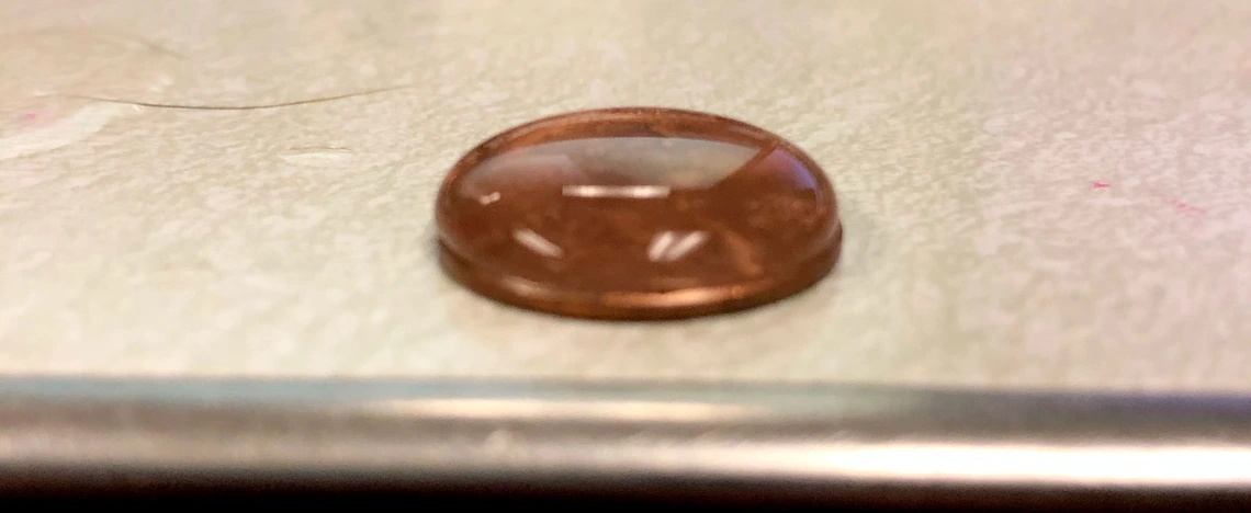 penny covered with water droplets penny covered with water droplets