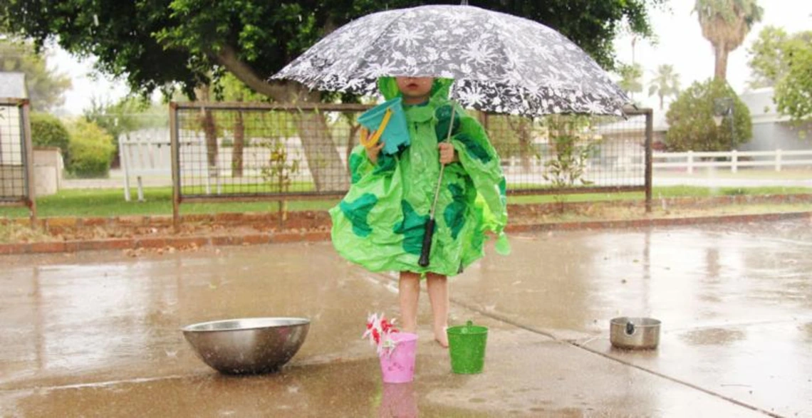 Giving Tuesday! girl holding umbrella and collecting water