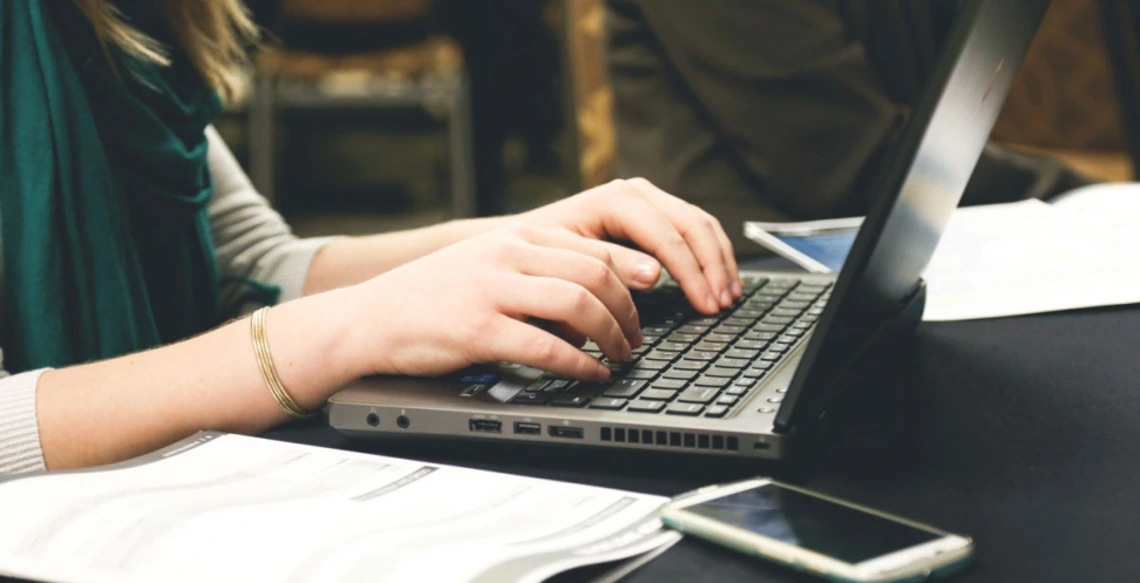 Reminder to Apply for WRRC Summer Writing Internship person typing at keyboard