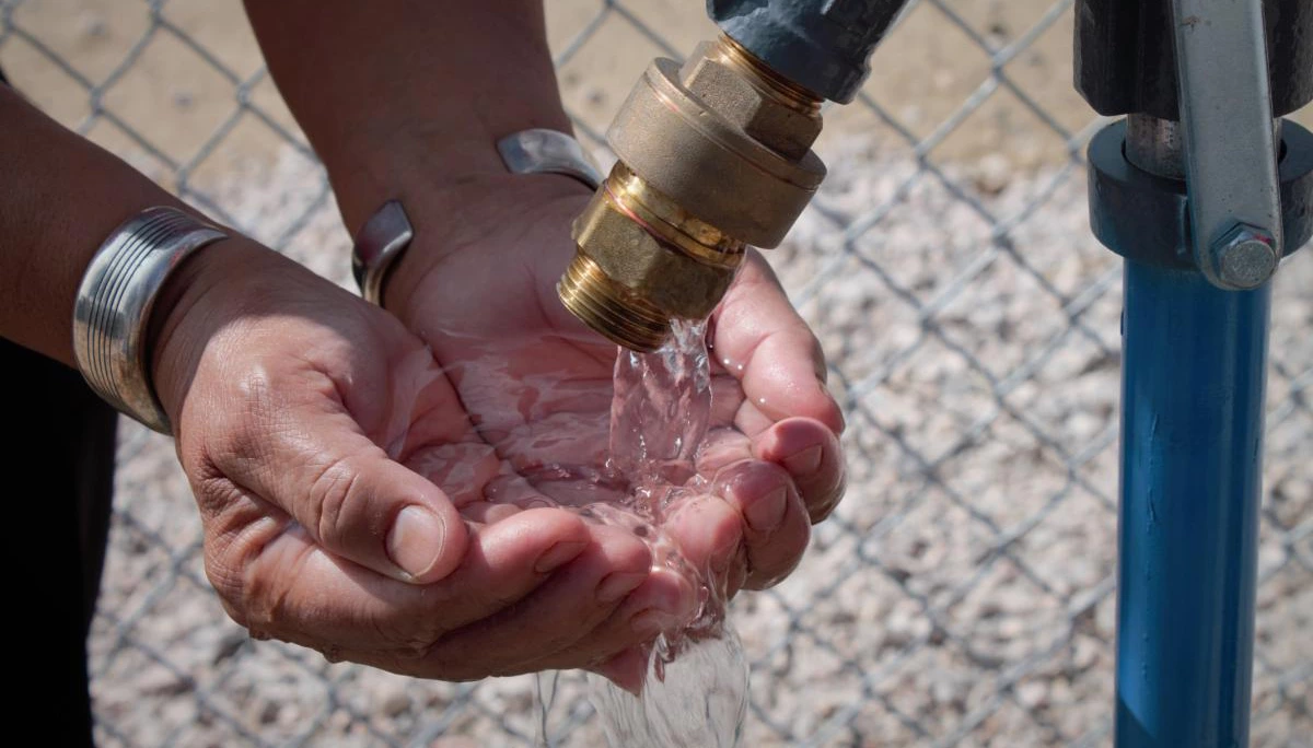 Cupped hands under running faucet Cupped hands under running faucet